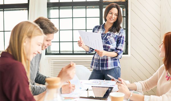 Team arbeitet rund um einen Tisch zusammen 